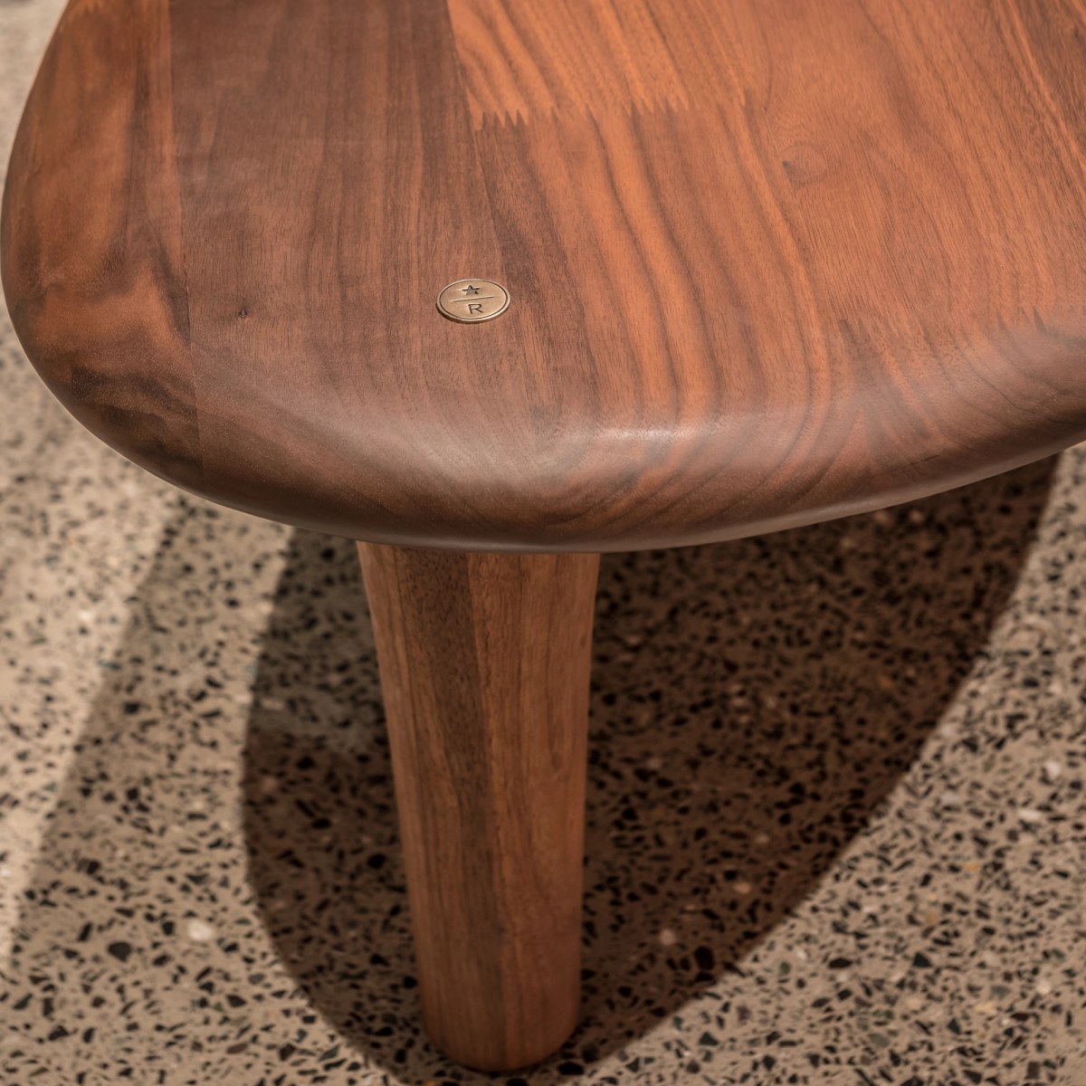Corner of walnut bench with Starbucks Roastery coin detail
