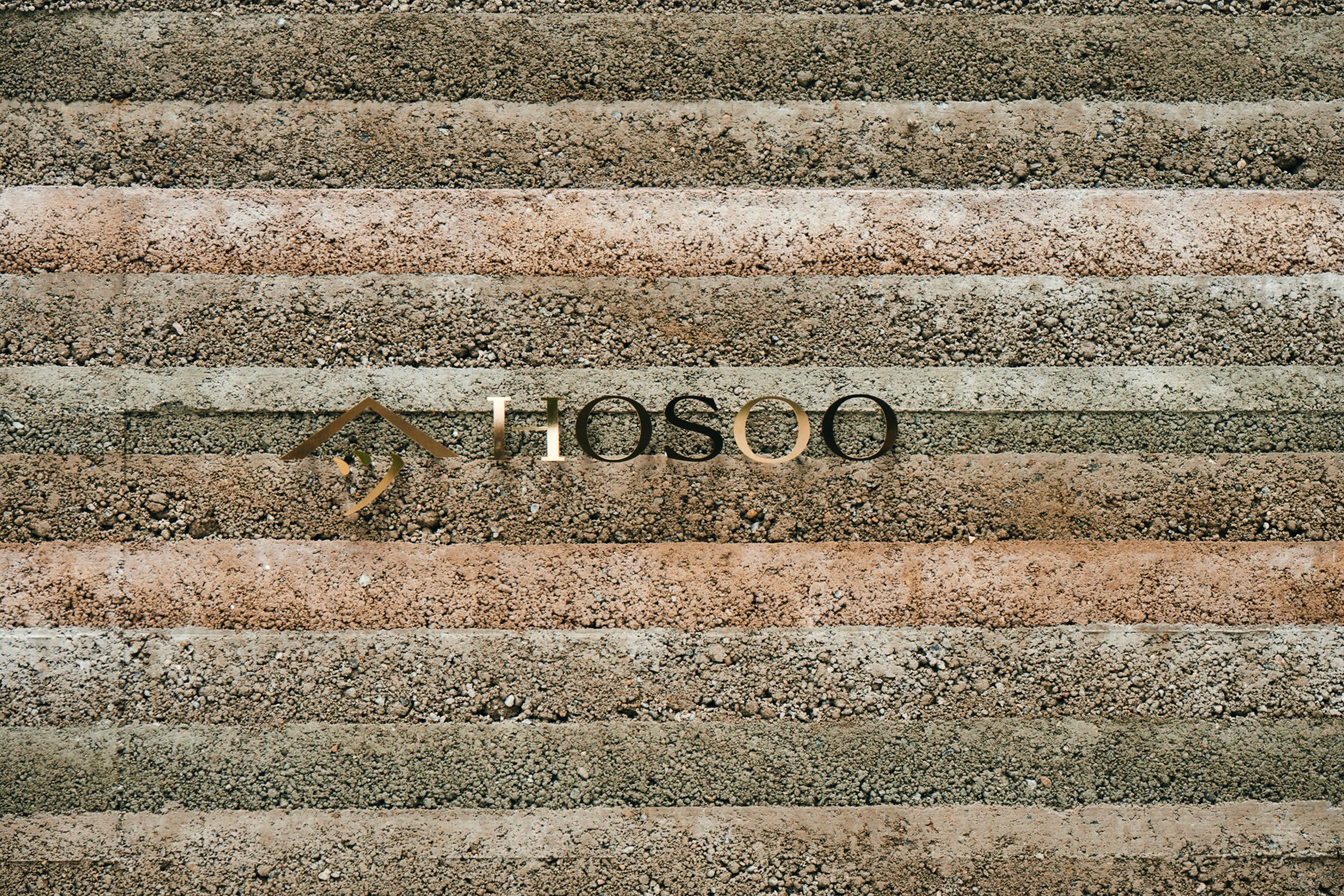 Hosoo logo on rammed earth walls