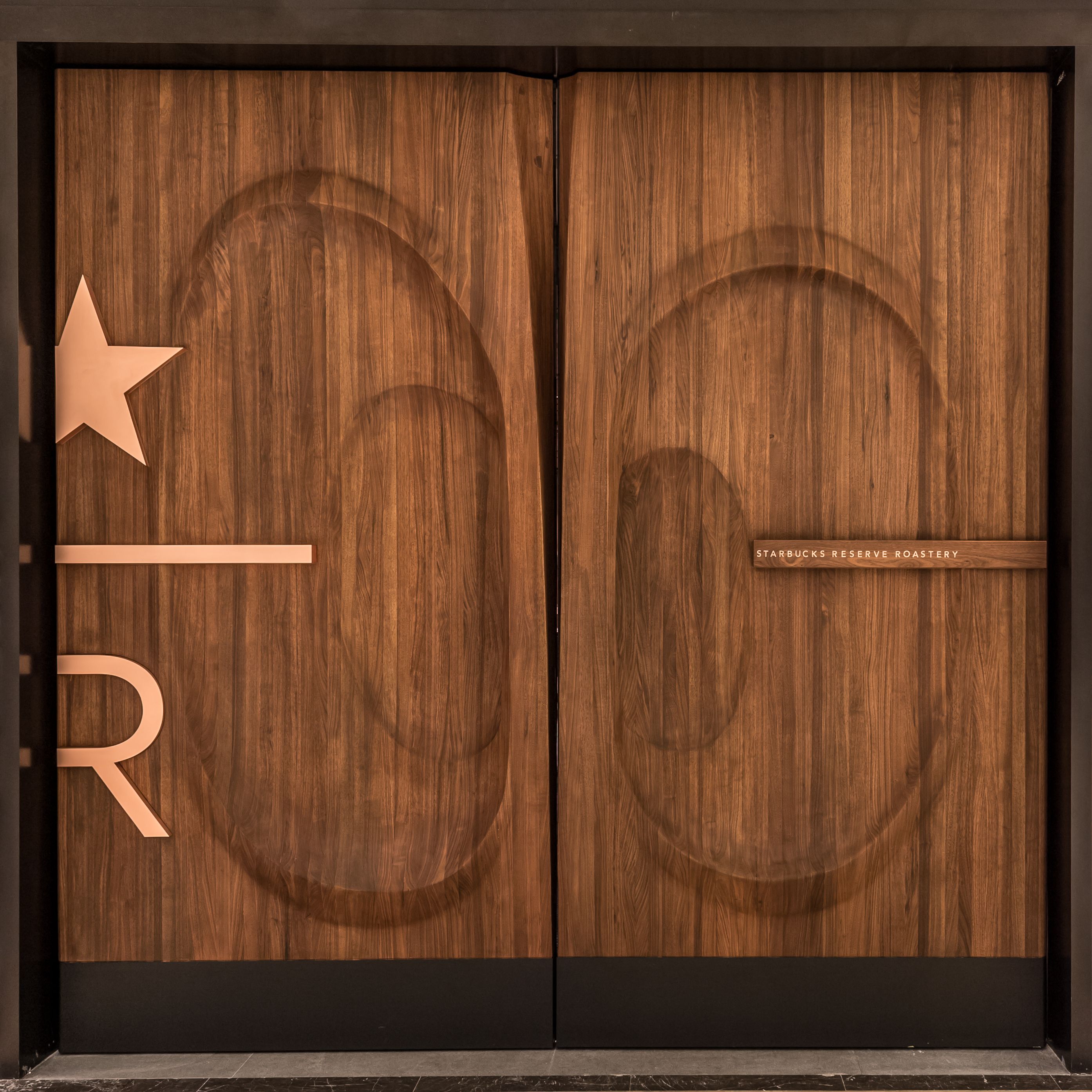 Large wooden walnut door with Starbucks Roastery logo