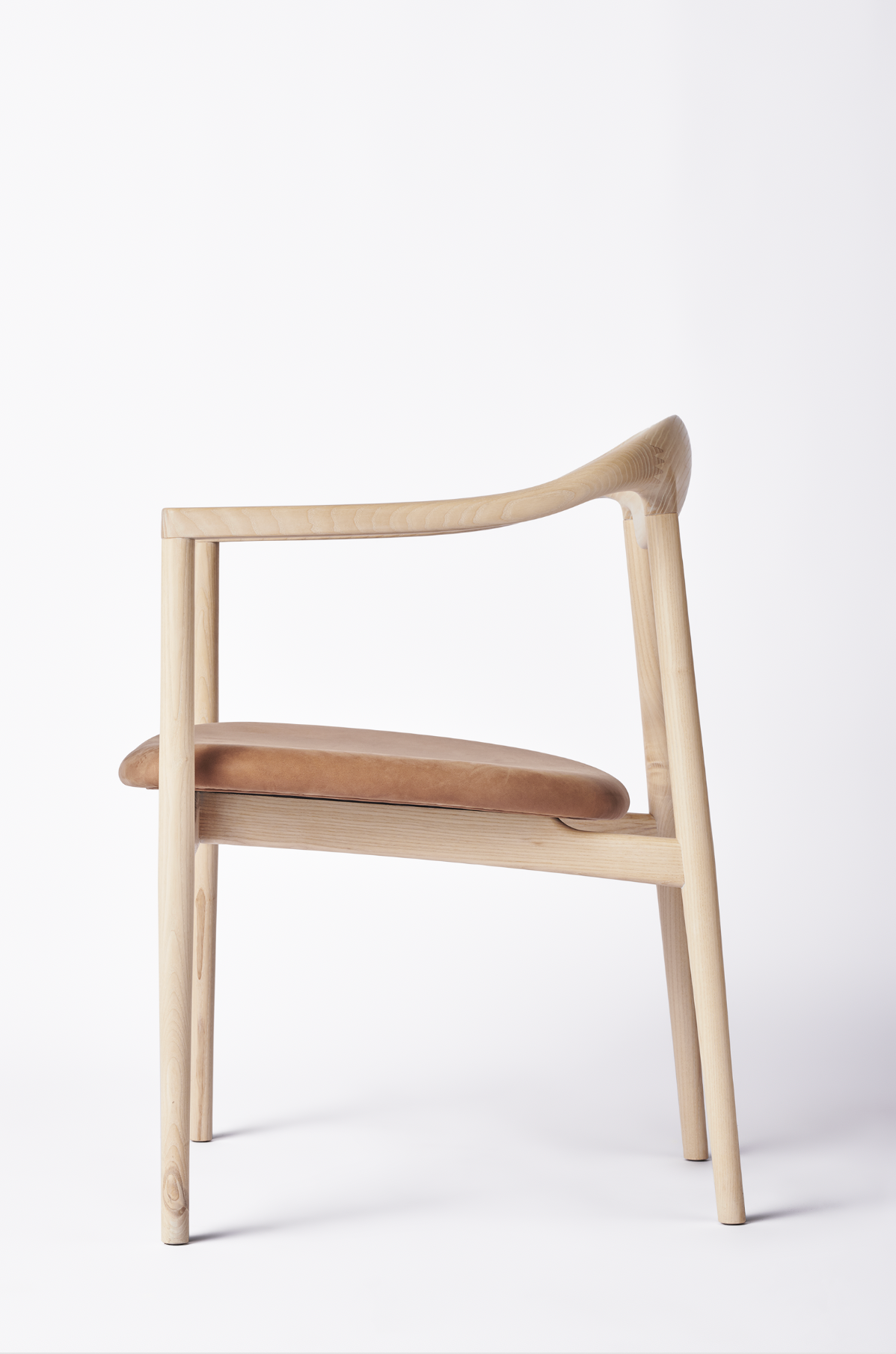 Sideview of wooden dining chair with upholstered leather seat