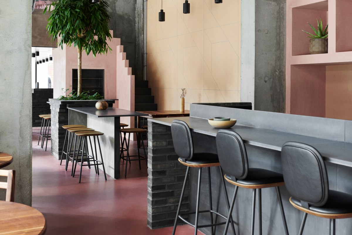 Restaurant environment with red floors, pink and yellow walls, bricks and metal elements