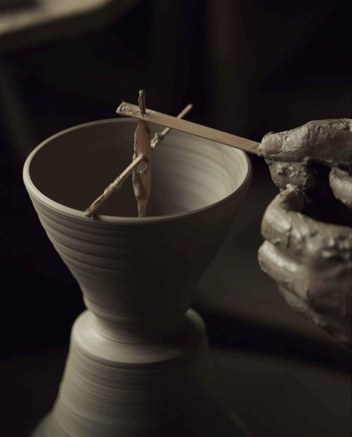 A vessel is shaped by hand in a traditional ceramic workshop
