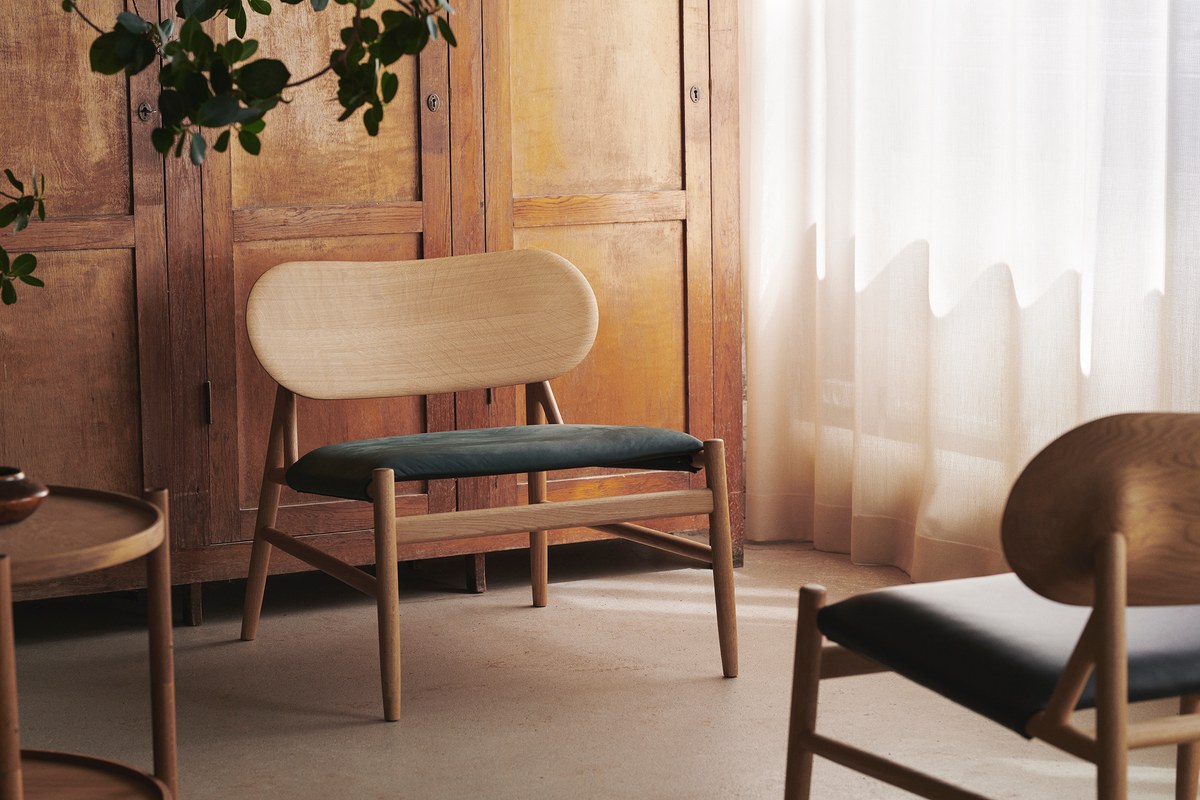 Wooden lounge chairs with textile seats, a wooden cabinet and a round wooden coffee table