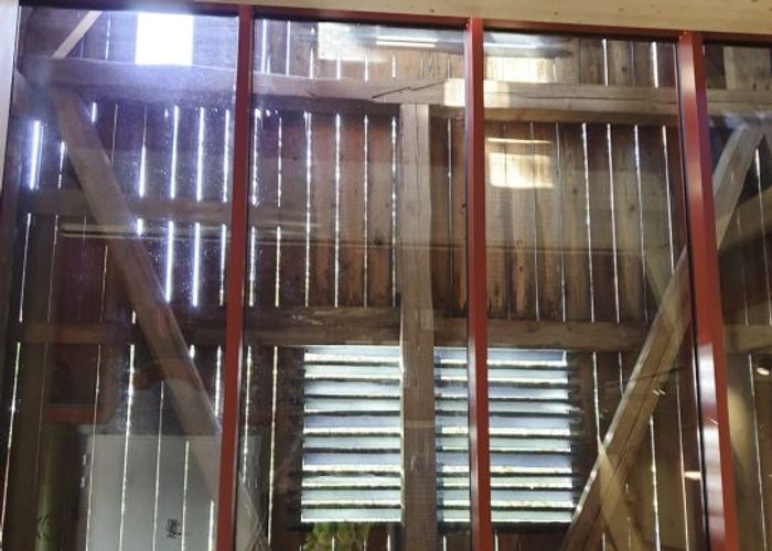 Den södra väggen i entrén mittemot porten är inglasad och silar ljuset vackert.