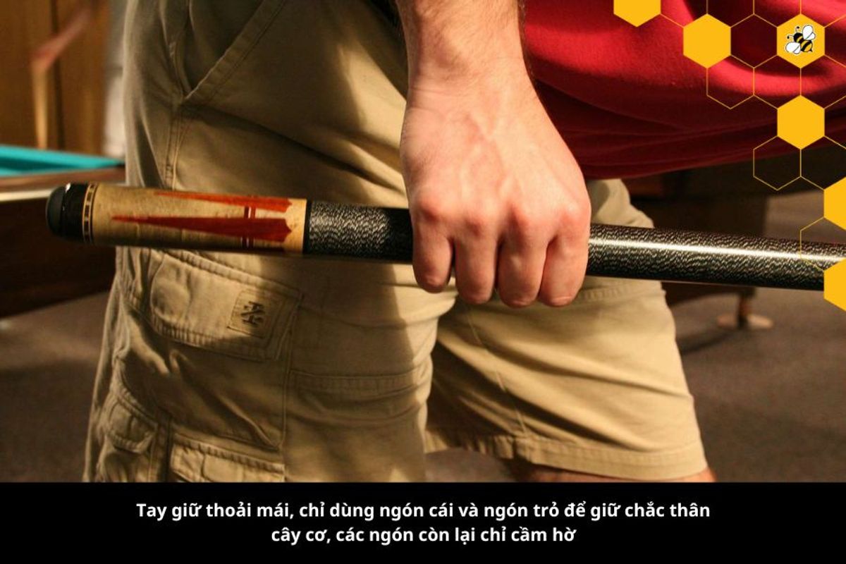 Tay giữ thoải mái, chỉ dùng ngón cái và ngón trỏ để giữ chắc thân cây cơ, các ngón còn lại chỉ cầm hờ