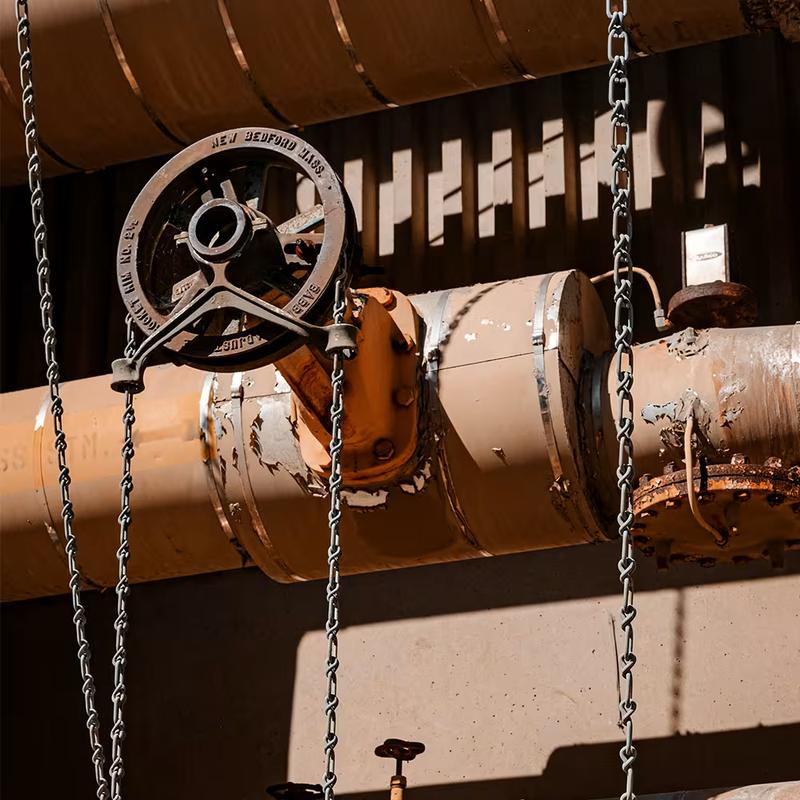 Corroded pipe with a hand-wheel valve and hanging chains