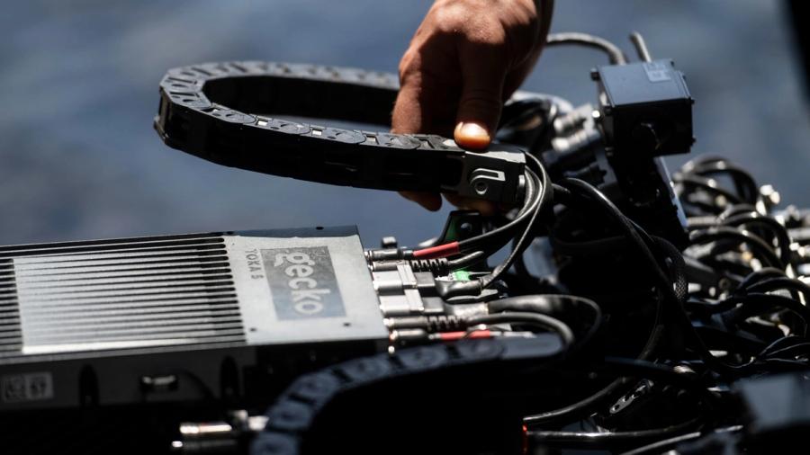 Close-up of a hand adjusting the cables on a Gecko TOKA robot