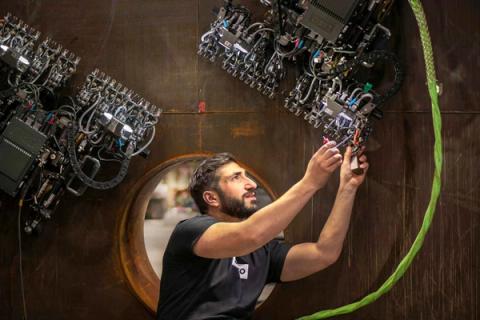 Gecko engineer connecting crawler robots on a steel tank wall