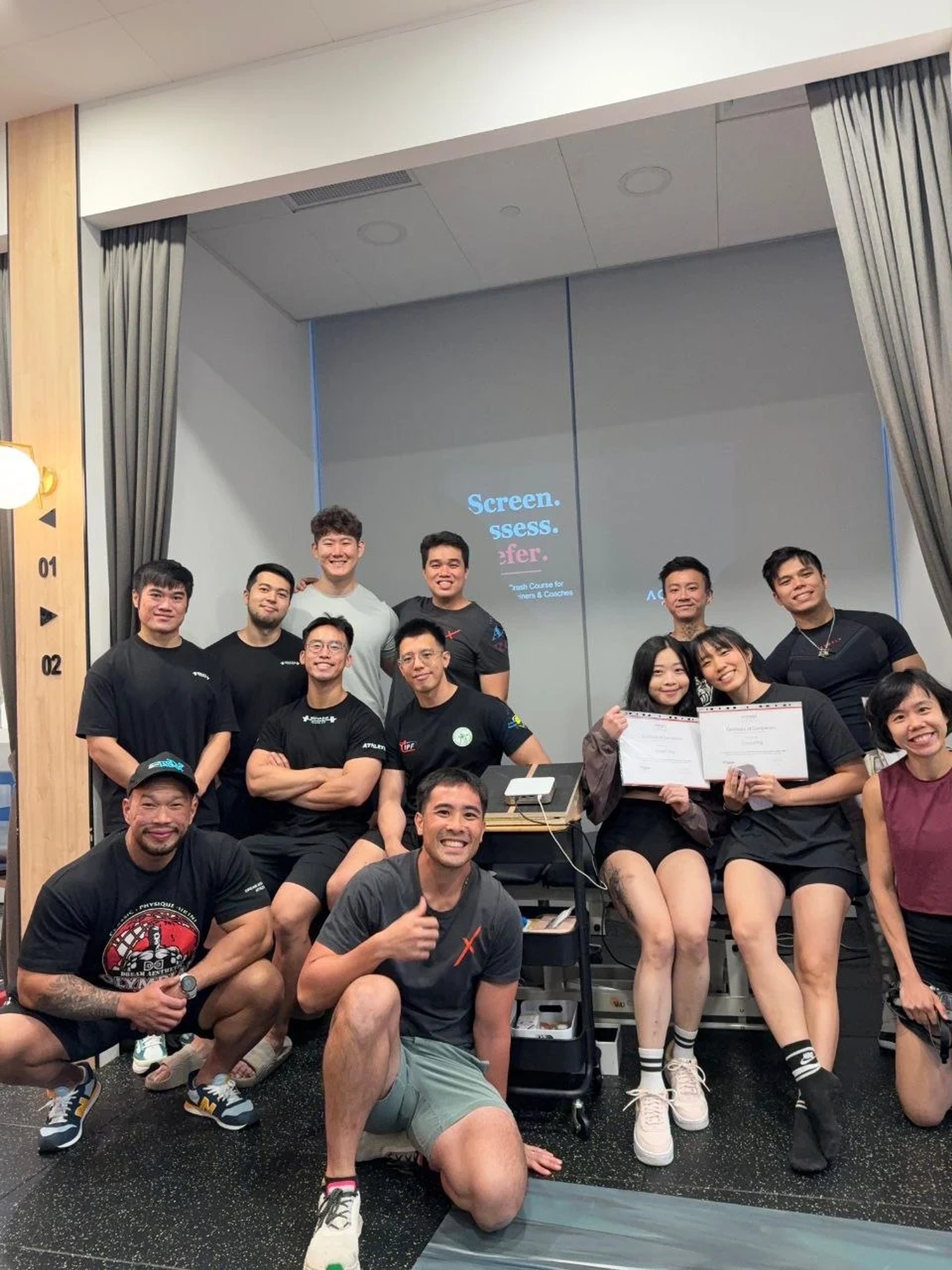 Group photo of physiotherapists and personal trainers at ActiveX Physiotherapy Singapore after completing a Screen Assess Refer crash course for trainers and coaches, with participants holding certificates of completion