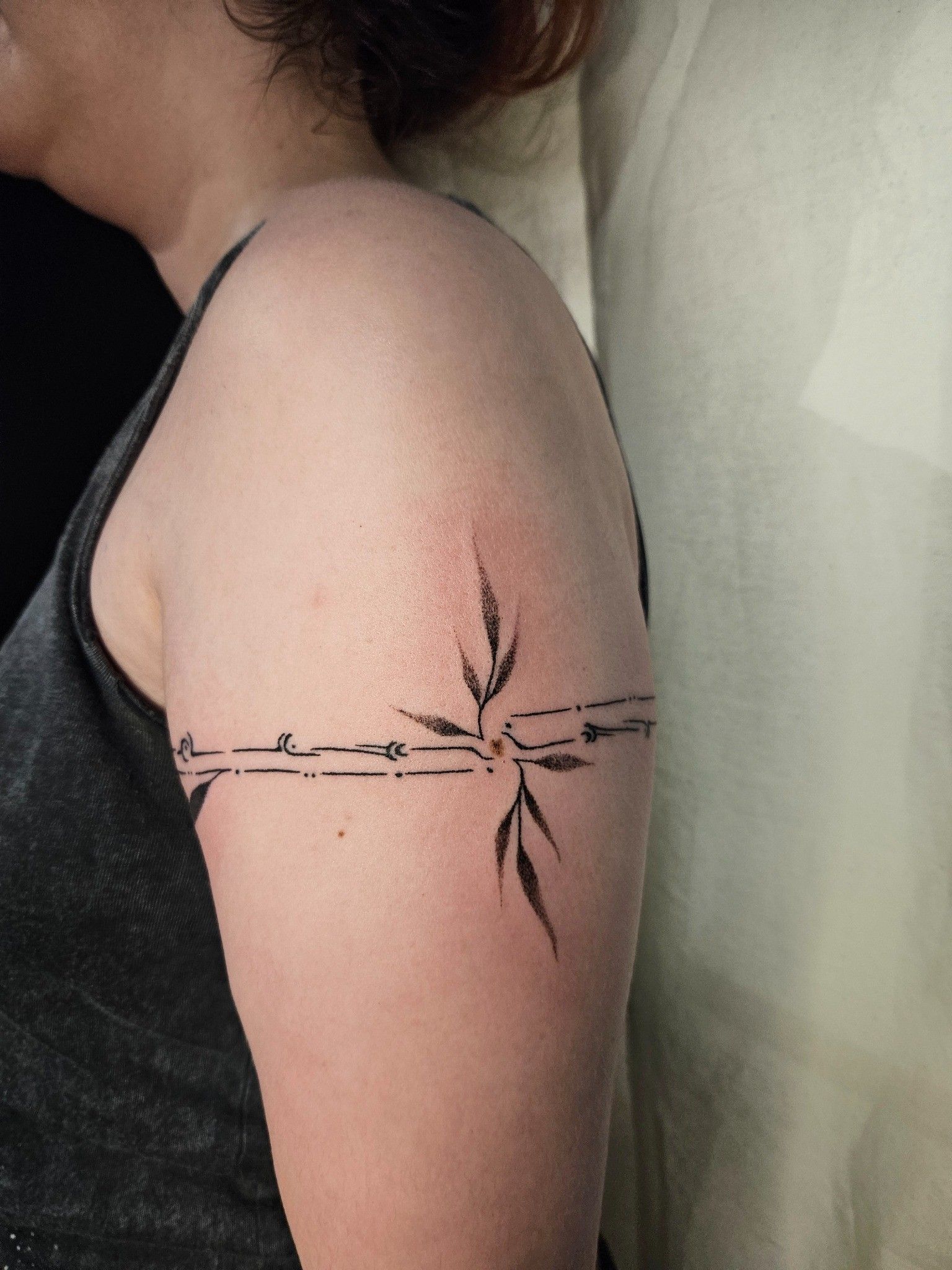 Tatouage bracelet de bras feuillage et ornement