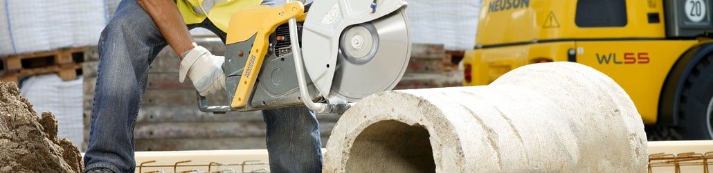 Wacker bandenzaag die rioolsbuis doorzaagt