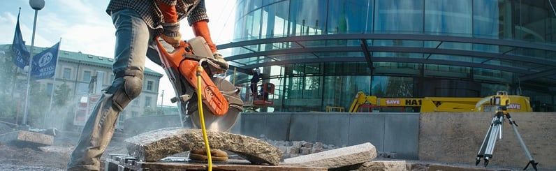 Bandenzaag Husqvarna in actie met een Spectra lader op de achtergrond
