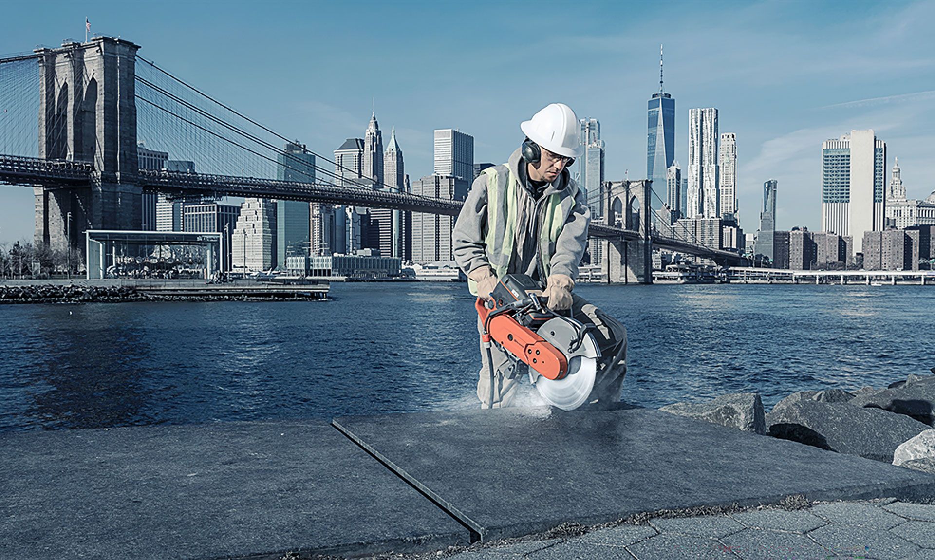 Man met Husqvarna bandenzaag aan het werk met de skyline van New York op de achtergrond