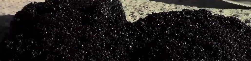 Close-up van een hoop koud asfalt op een ruwe ondergrond, klaar voor verwerking bij wegreparaties. Laat me weten als je een alternatieve versie wilt voor SEO, productbeschrijving of technische toepassing.