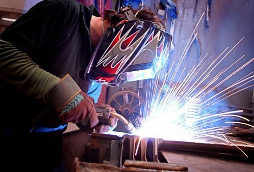 A man is welding metal with sparks flying