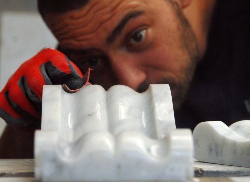 Man cleans a white marble corbel