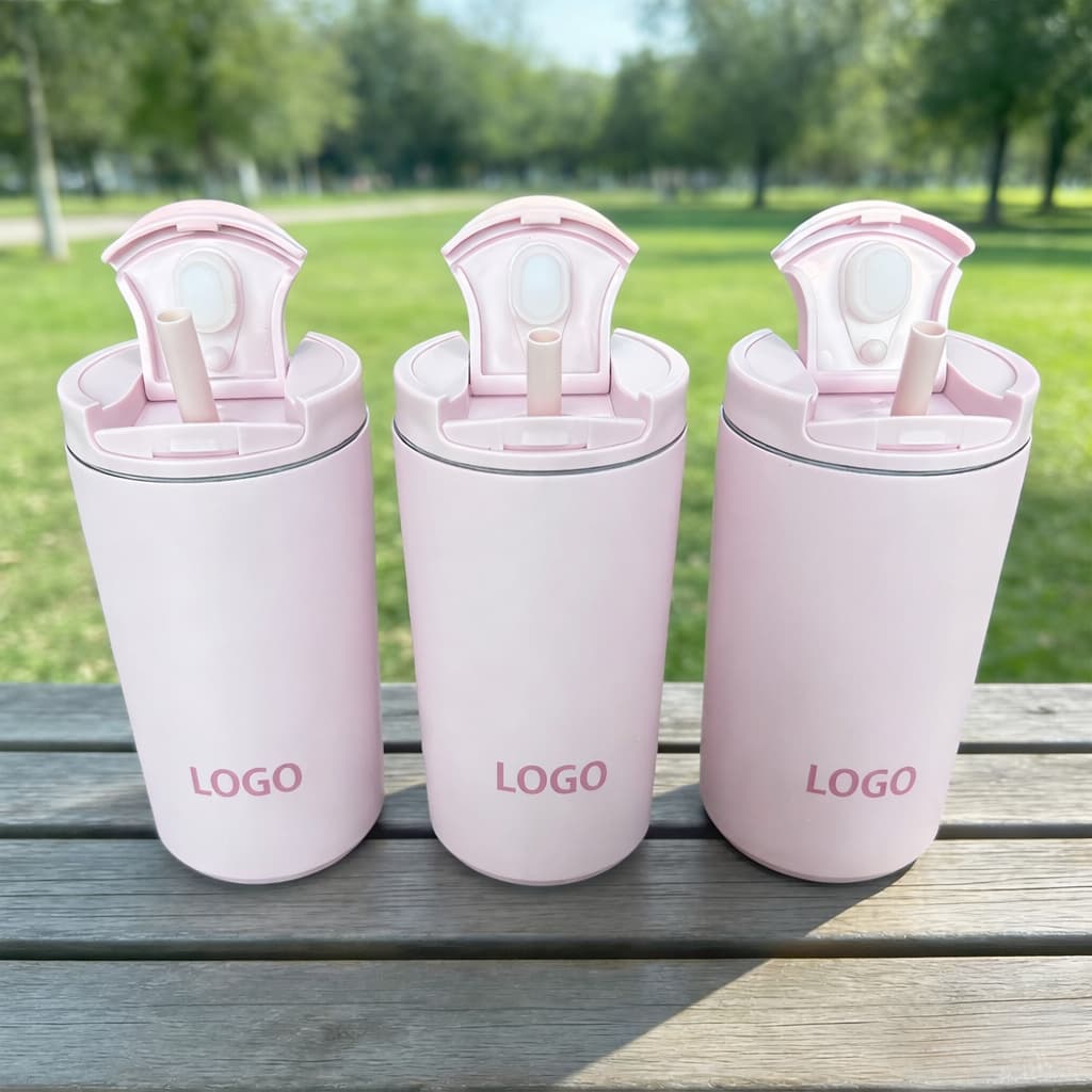 Three pink insulated straw tumblers outdoors on a wooden table, custom “LOGO” print