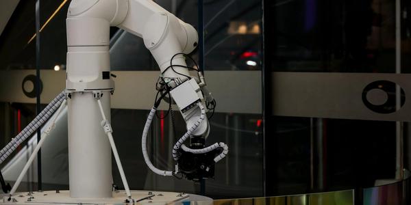 A white robotic arm operating indoors with a modern design and advanced technology.