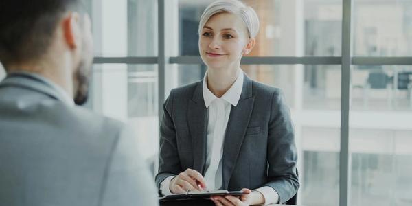 Confident woman interviewing candidate in a modern office. Ideal for business and HR visuals.