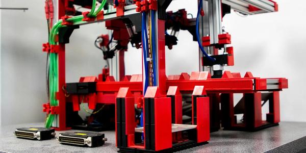Close-up view of a robotic assembly machine with vibrant red and metallic components.