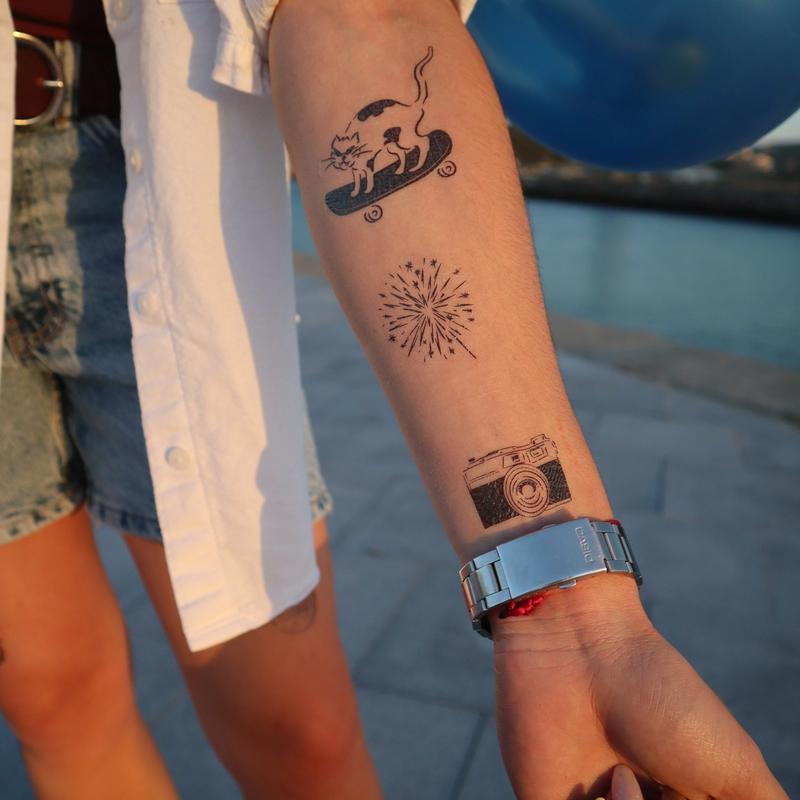 temporary tattoos on forearm, a camera a funny cat skating and fireworks
