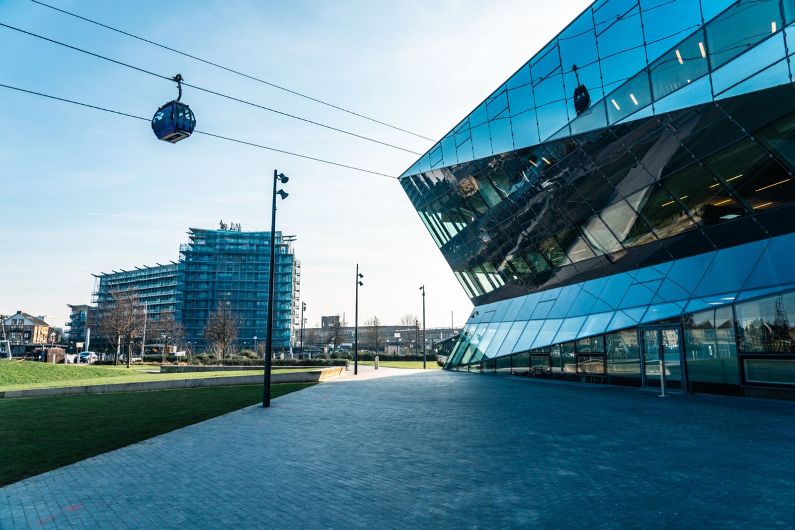 Emirates air line cable car moving over the crystal building in london's royal docks