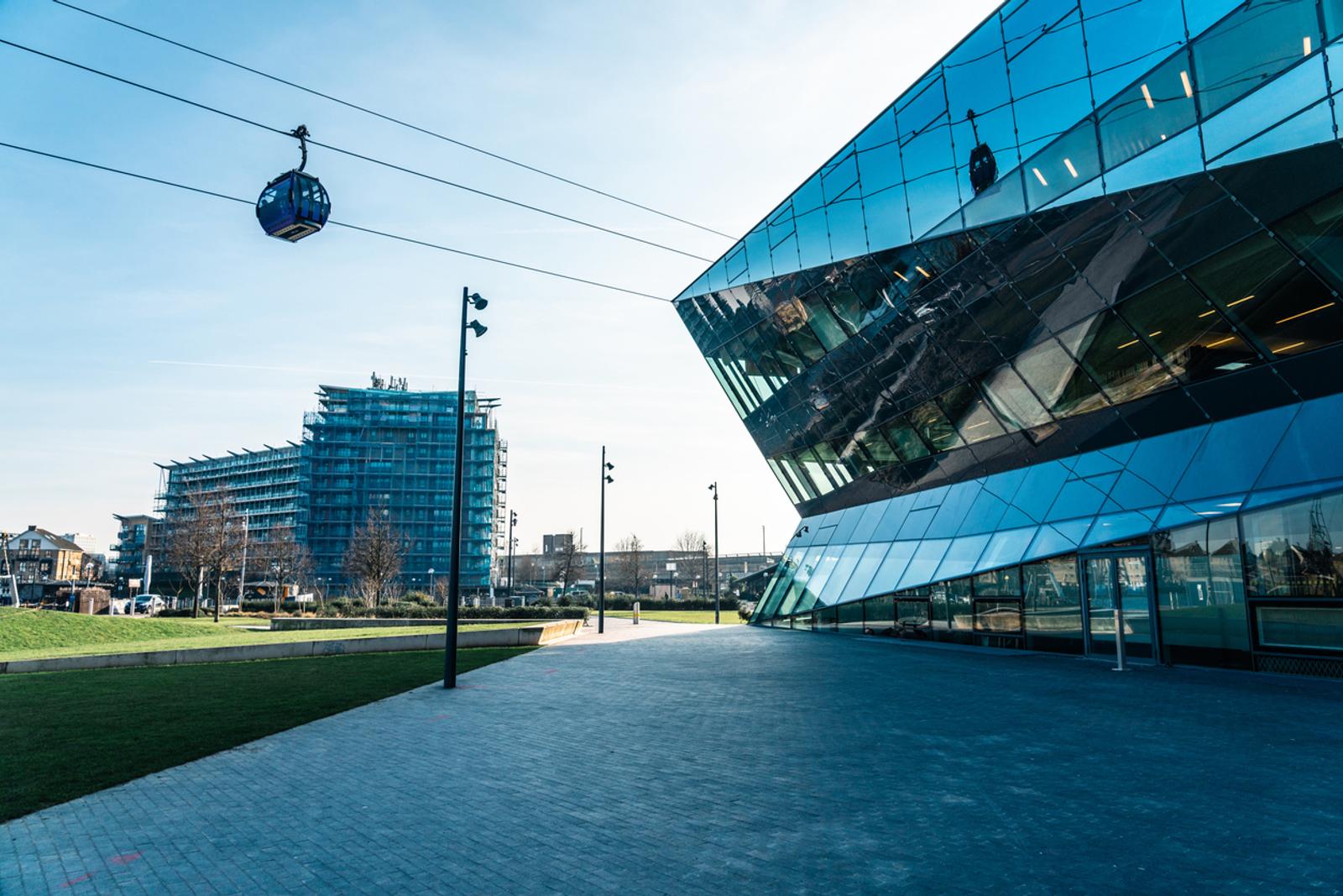 Emirates air line cable car moving over the crystal building in london's royal docks
