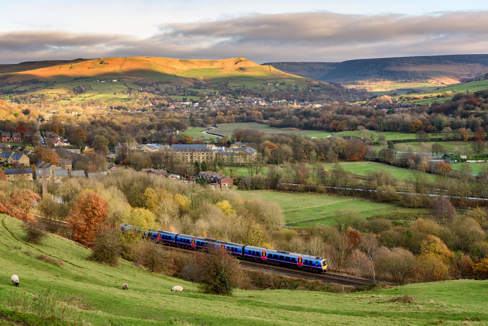 Passanger train passing through british countryside near greater Manchester, England.