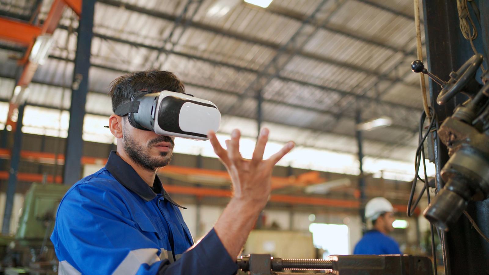 Engineer wearing virtual reality headset standing in the manufacturing factory.