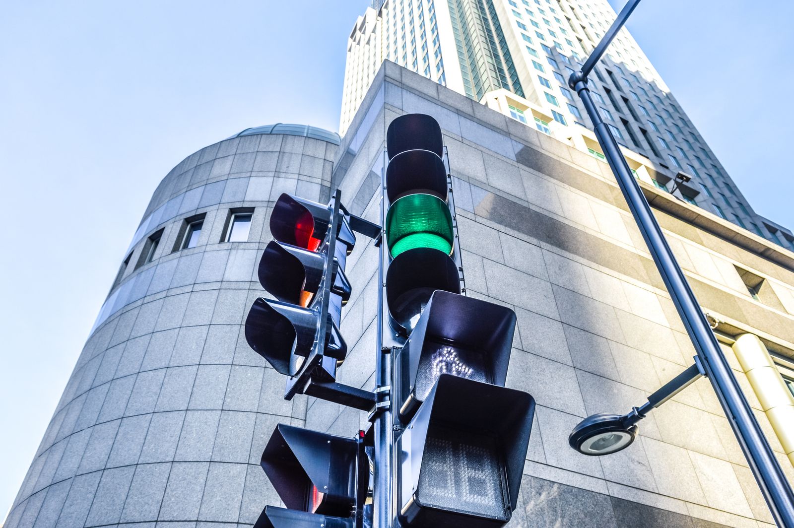 Red and green colors on the traffic light with pedestrian crossing indicator