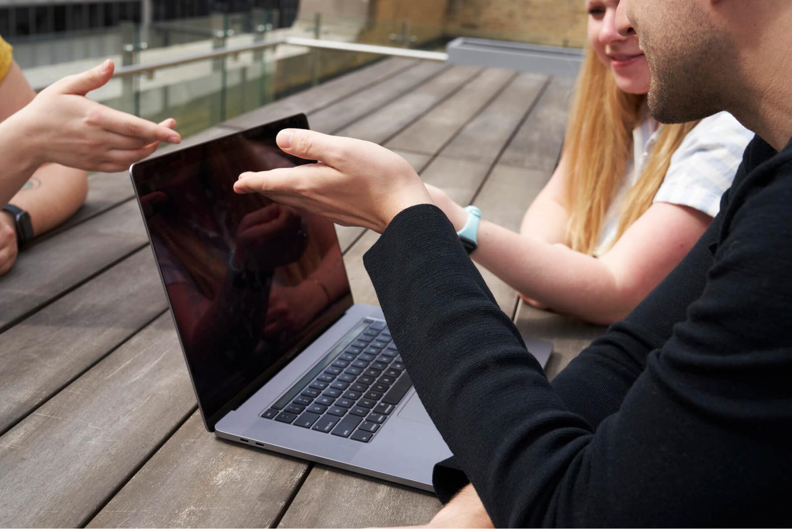 Hologram employees working outside at a table in front of a computer