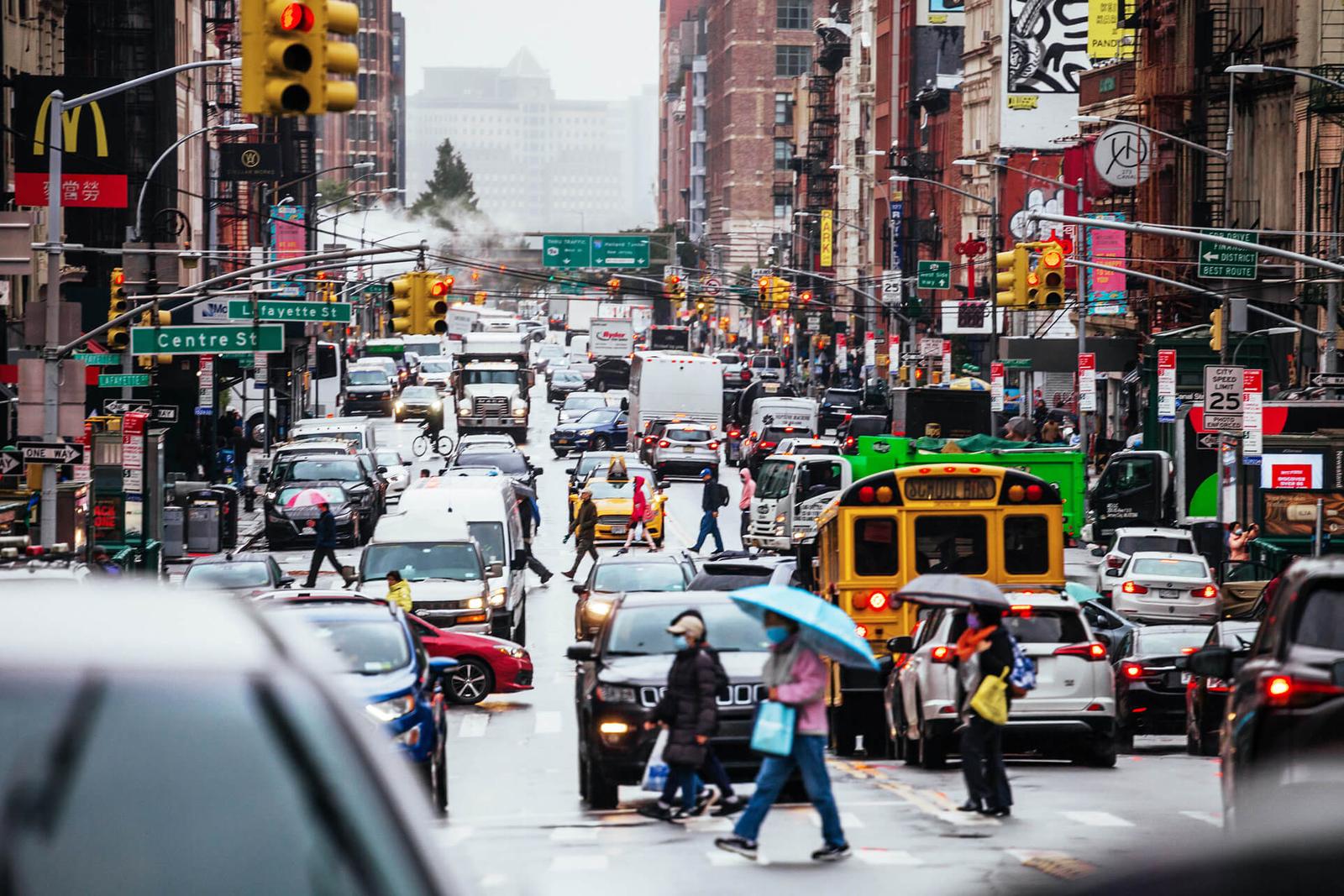 Crowded city street with people, busses, and cars