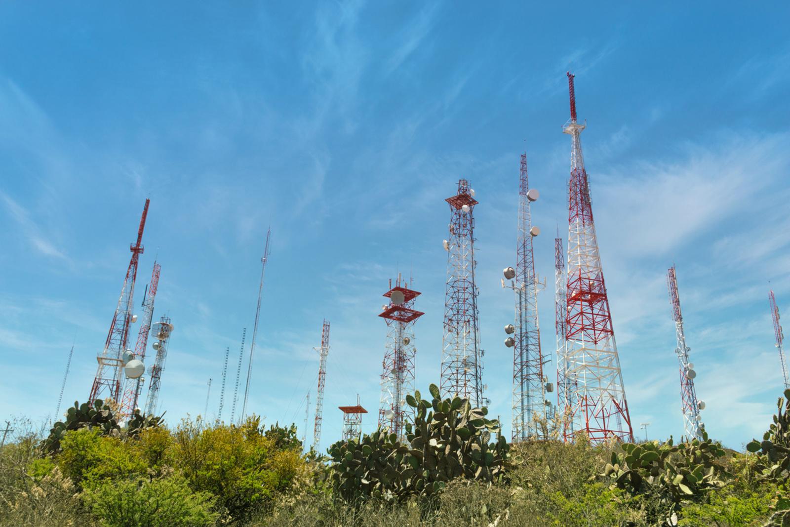 Group of telecommunication antennas sunny day, top of hill in mexico