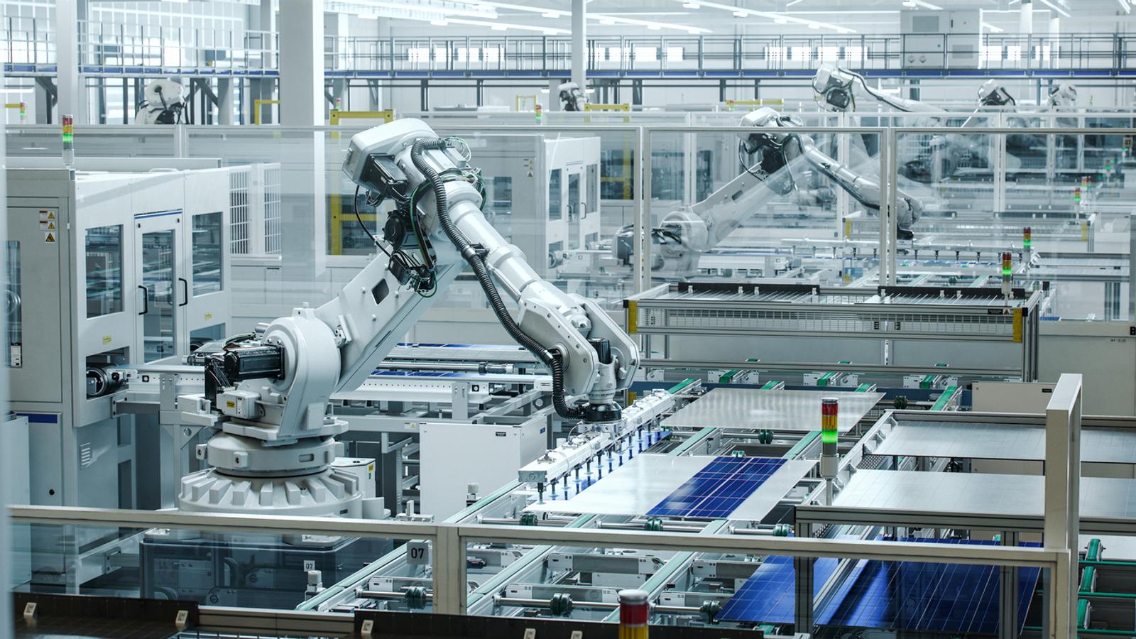 Solar Panels are being assembled on conveyor with a white industrial robot arm