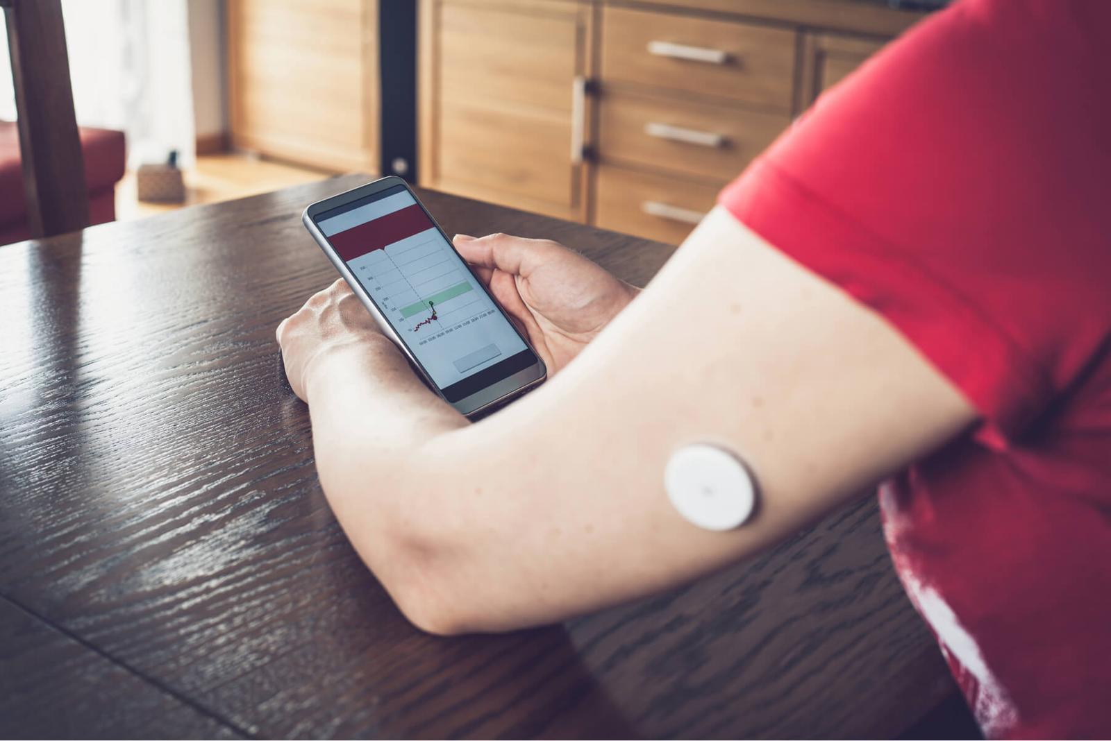 person using a remote patient monitoring device and tracking data on a cell phone