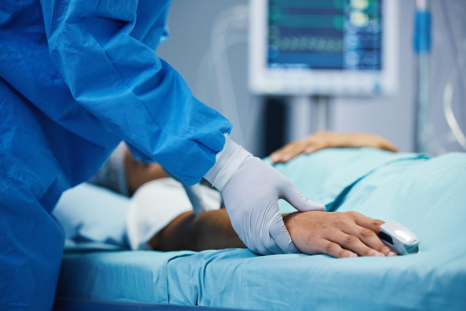 health practitioner using a sensor to track patient in surgery's vital signs