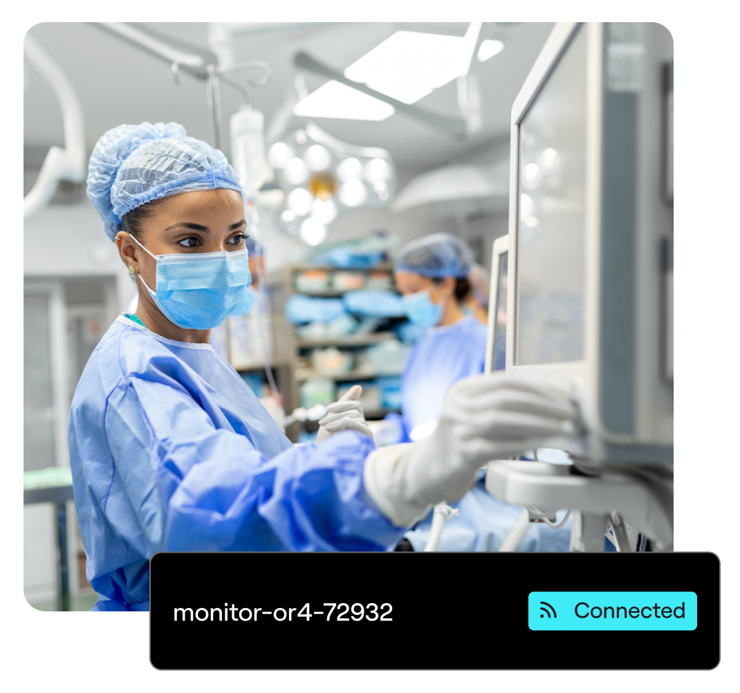 A surgeon touches a monitoring device in an emergency room