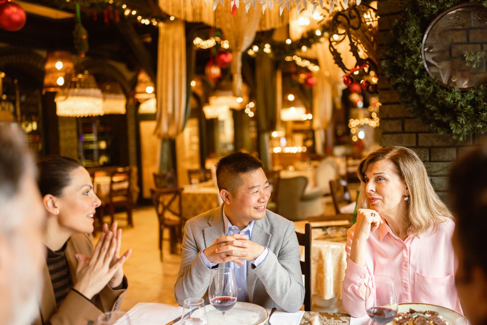 Four business people having dinner in luxury restaurant