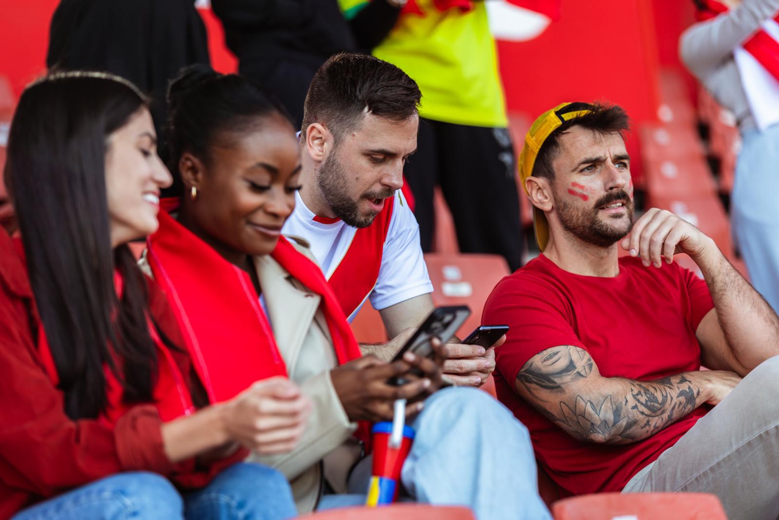 ports fans using their phone at the game in the stadium getting notifications for promotions mid game