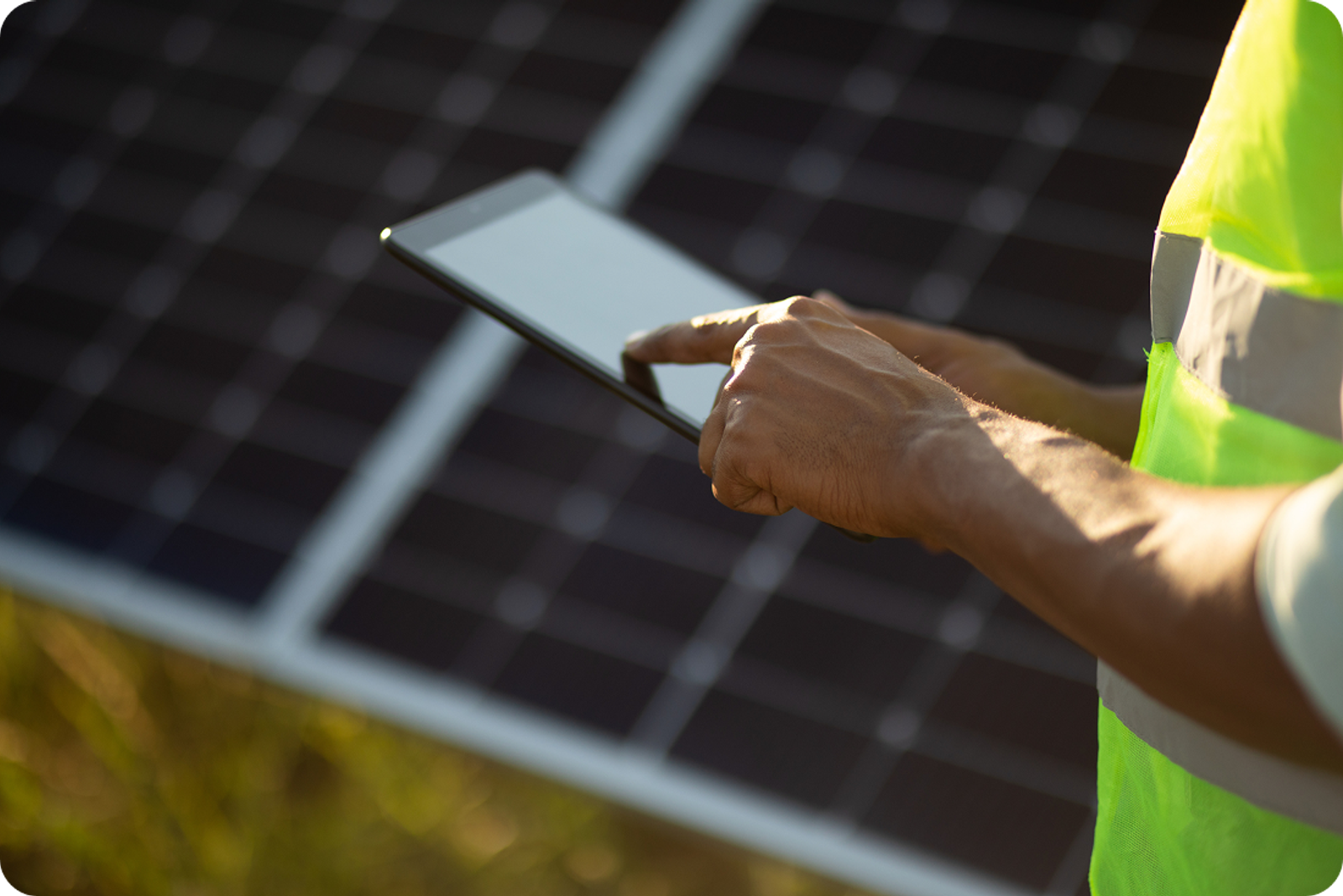 A person uses a tablet near a solar panel