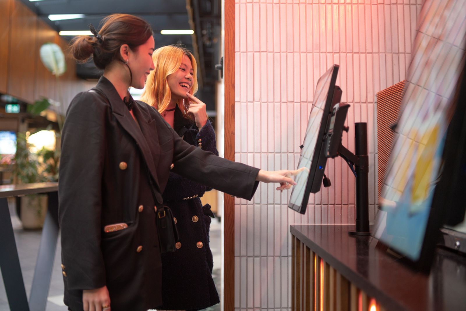 A woman uses a large touch-screen kiosk