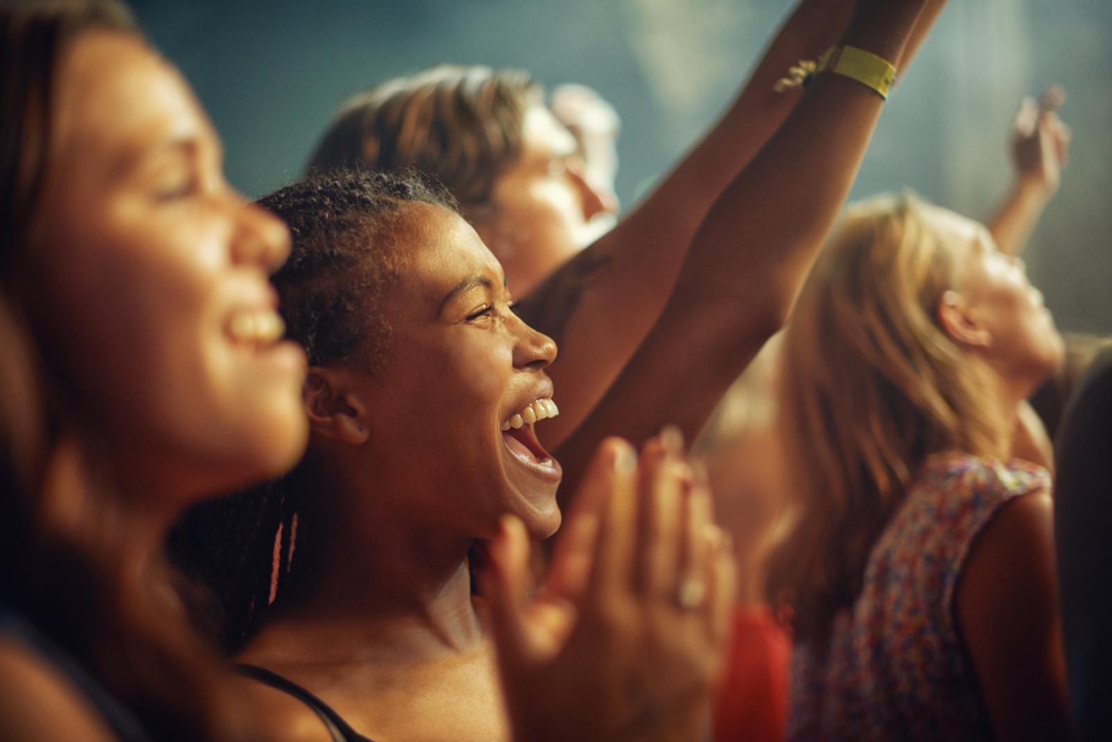 Close up of fans faces of all genders and races at a event