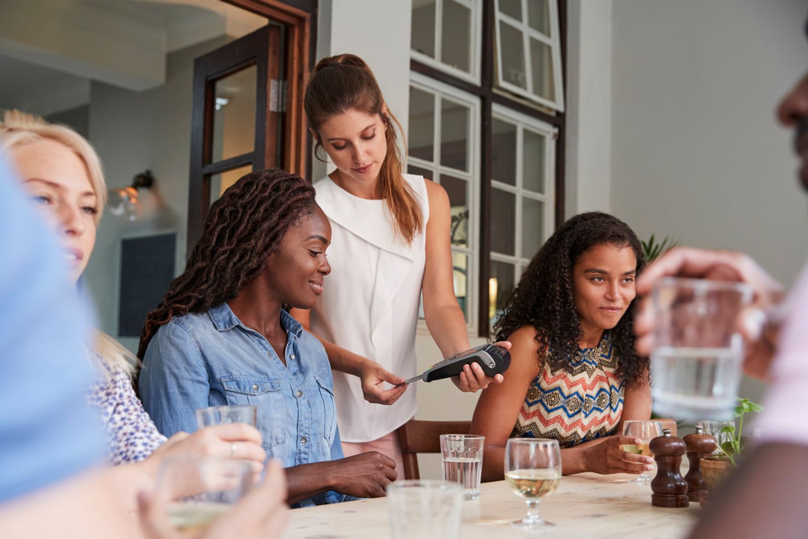 Female Customer In Restaurant Paying Bill Using mobile POS 