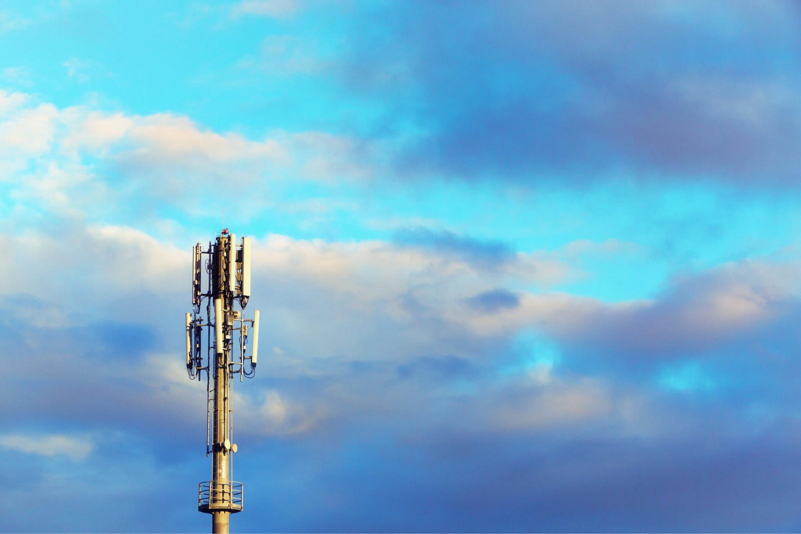 cell tower rising into a blue sky