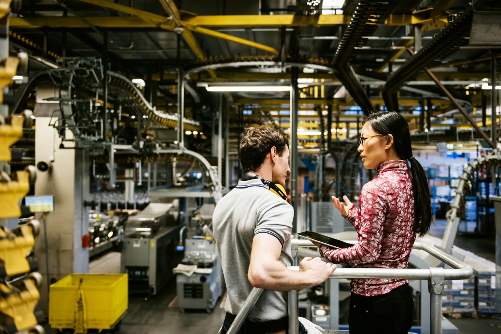 Team members look at a tablet in a factory