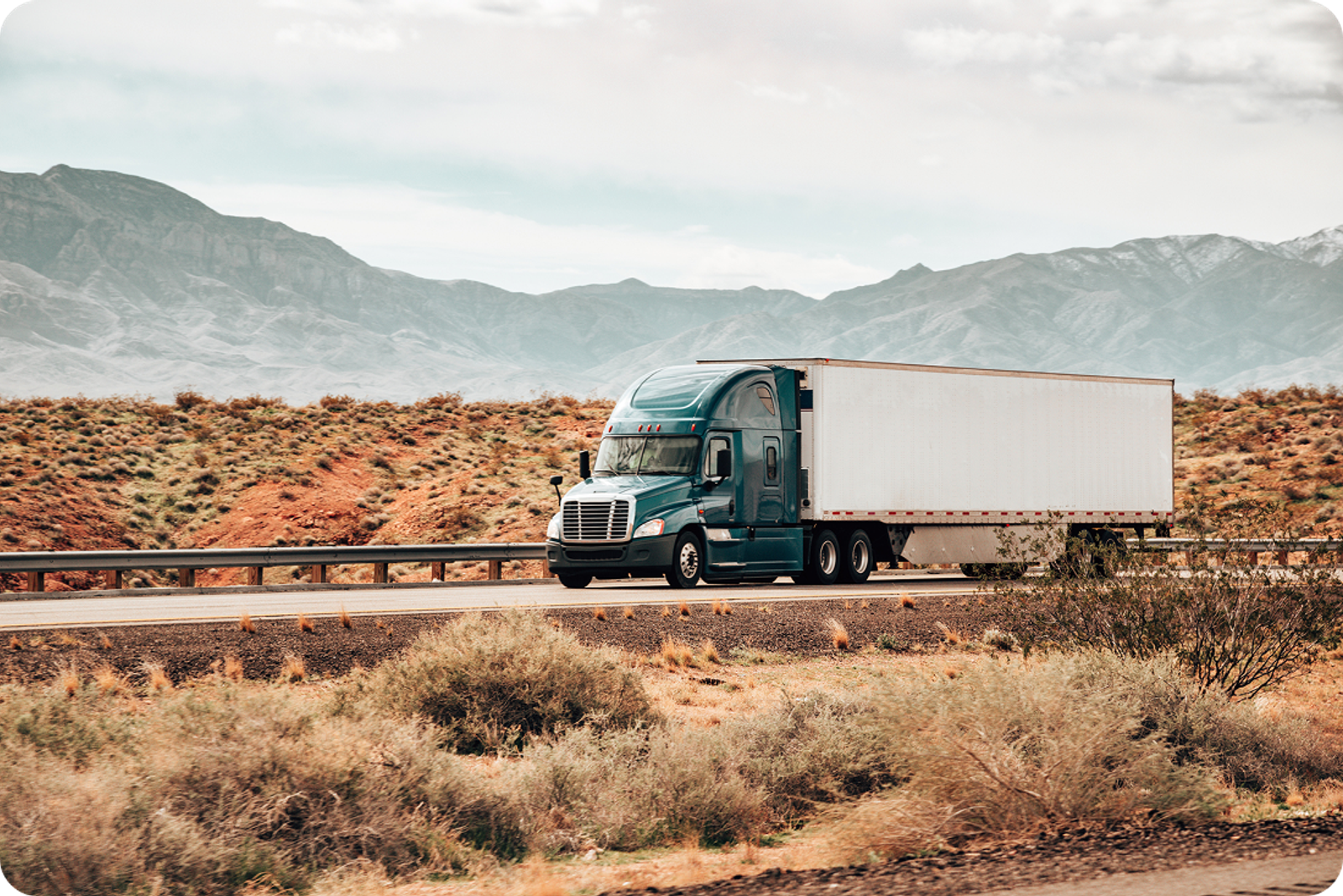 A long haul truck drives through the desert