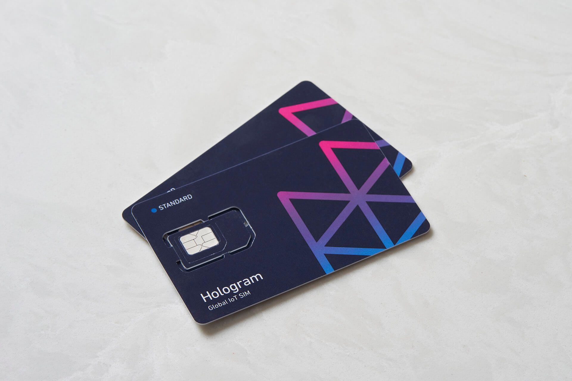 Two Hologram sim cards sitting on a countertop 