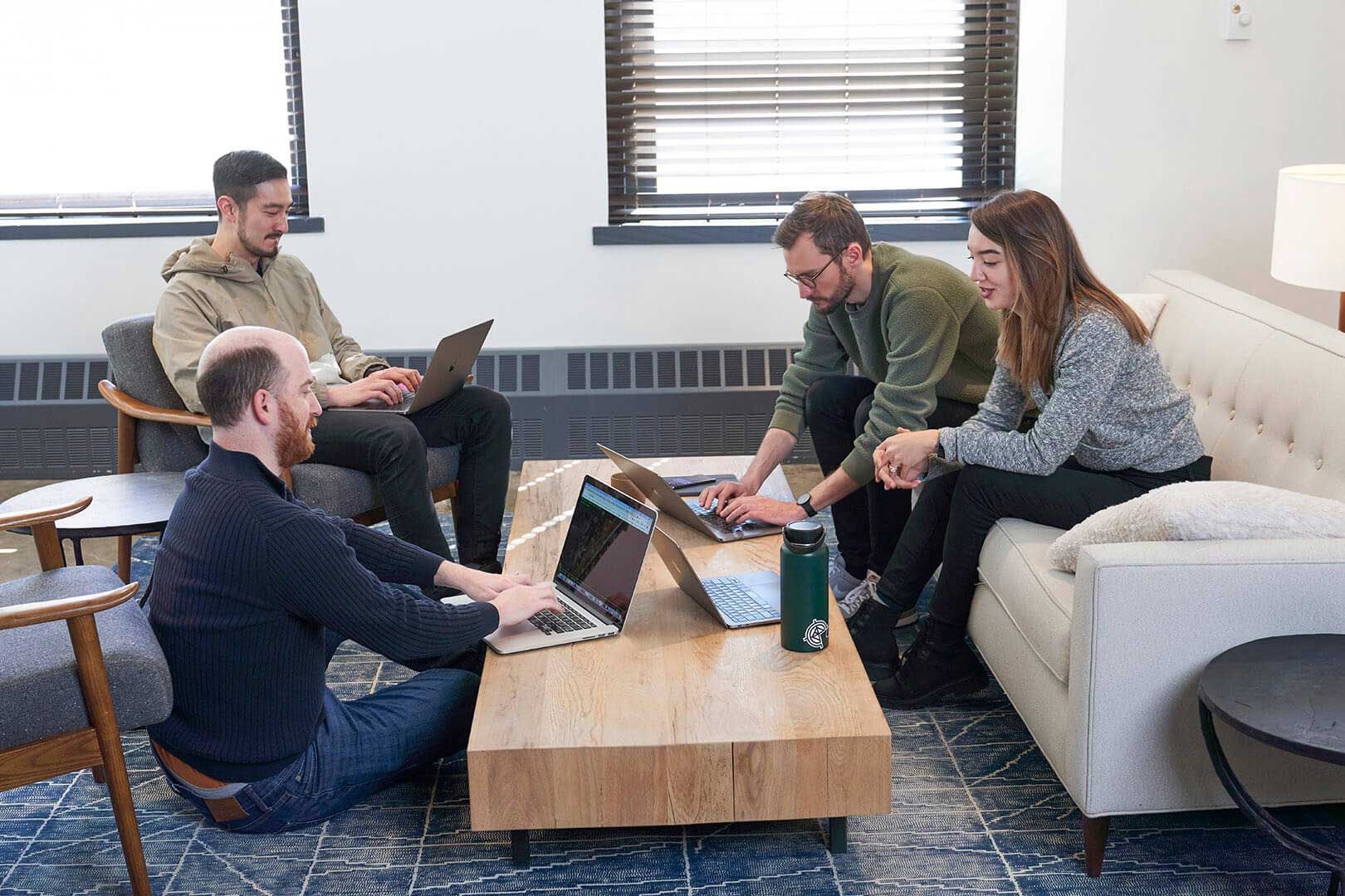 Hologrammers sit around a coffee table in the office and work together