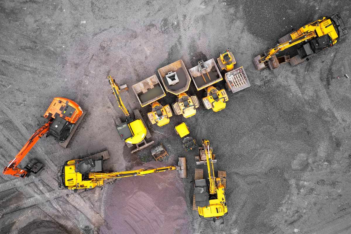 An aerial view of a construction site with yellow and orange diggers