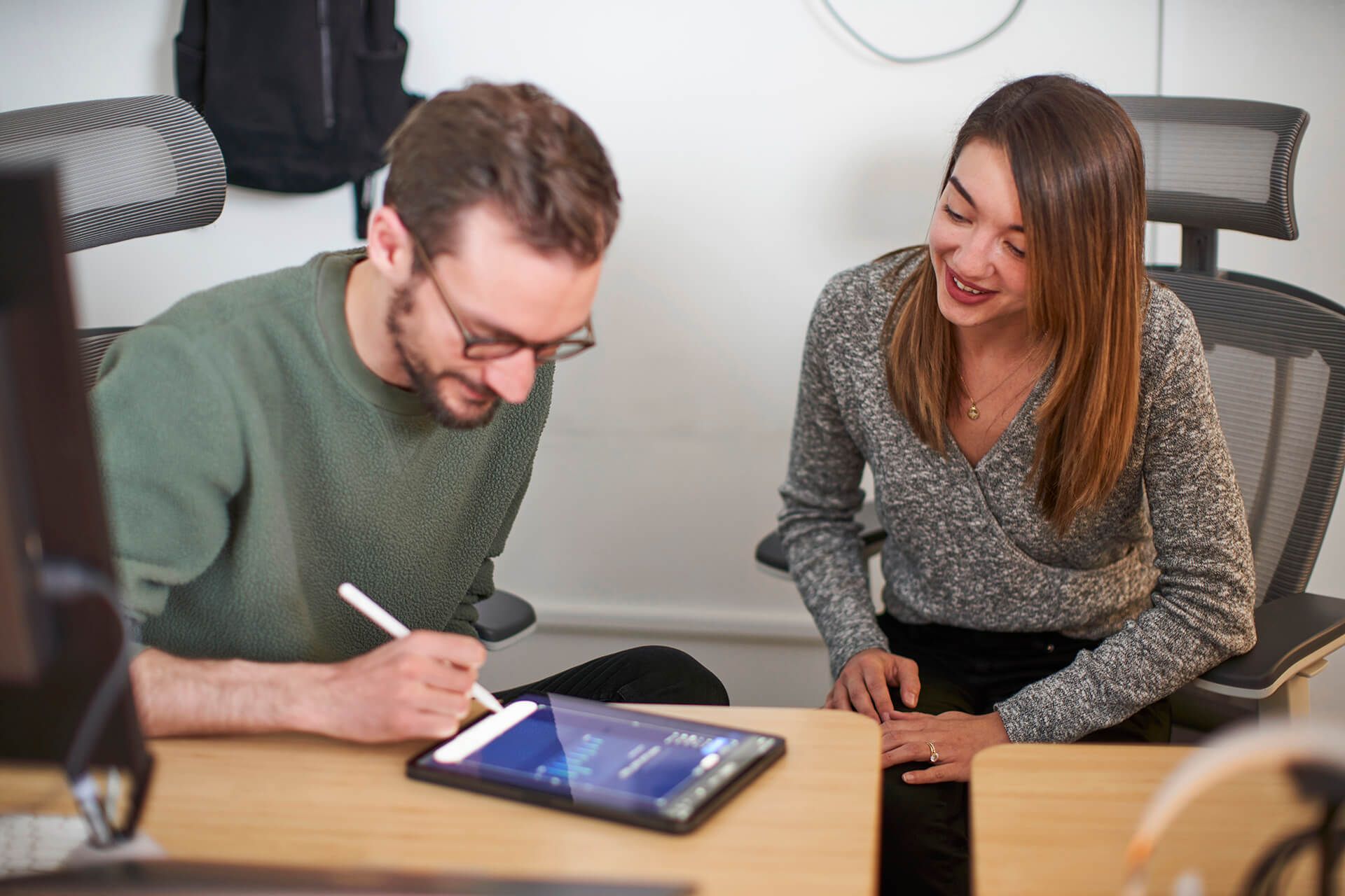 Hologram Senior Product Designer Sean Nelson and Sales Manager Allison Blade collaborate over an iPad in the Hologram office.